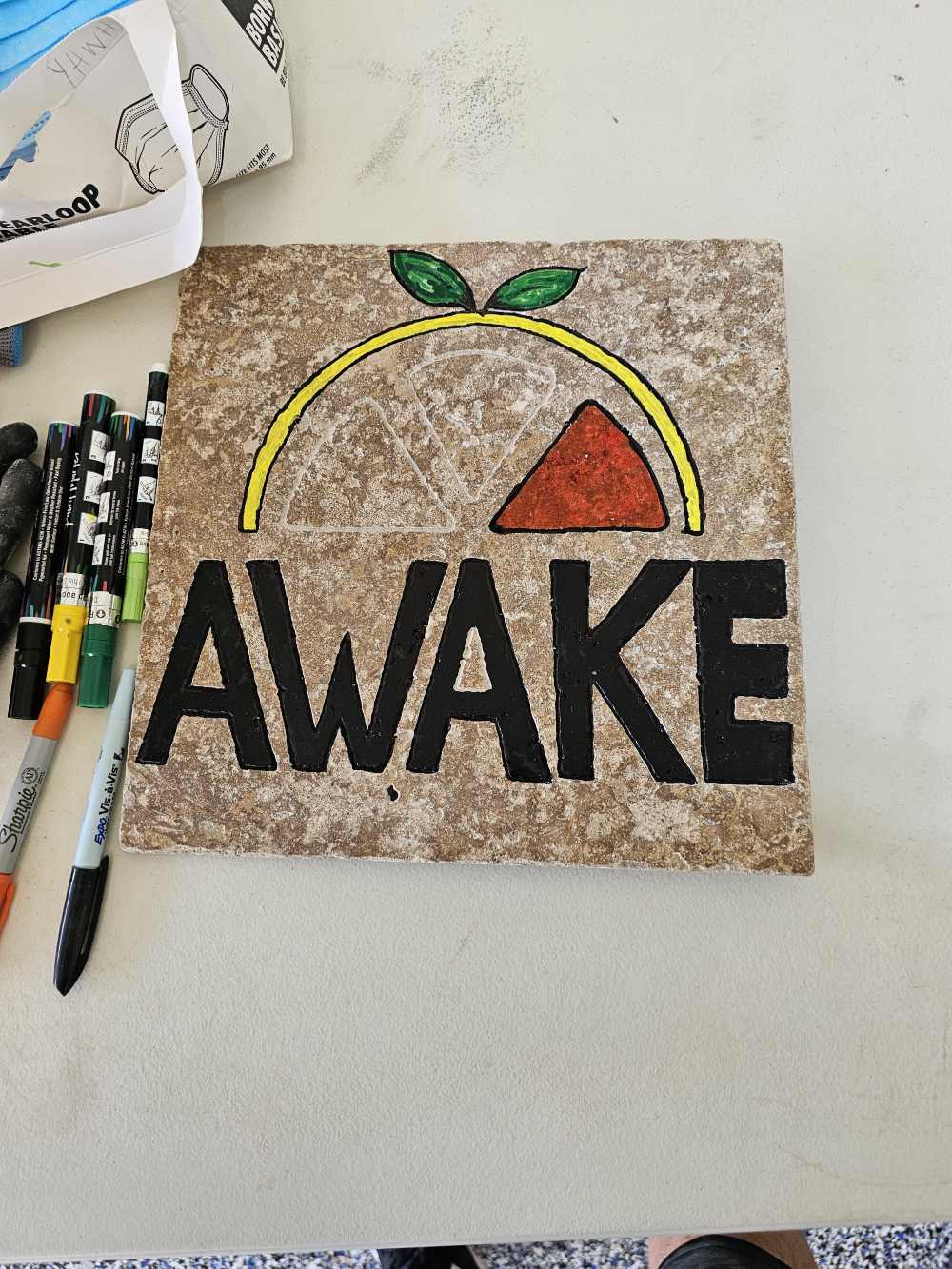 A close up of the word awake on top of a tile.